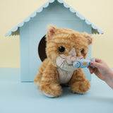 A close up of a child's hand holding the magnetic blue fish in front of the Olli Ella Koda dinkum cat doll available at Babipur