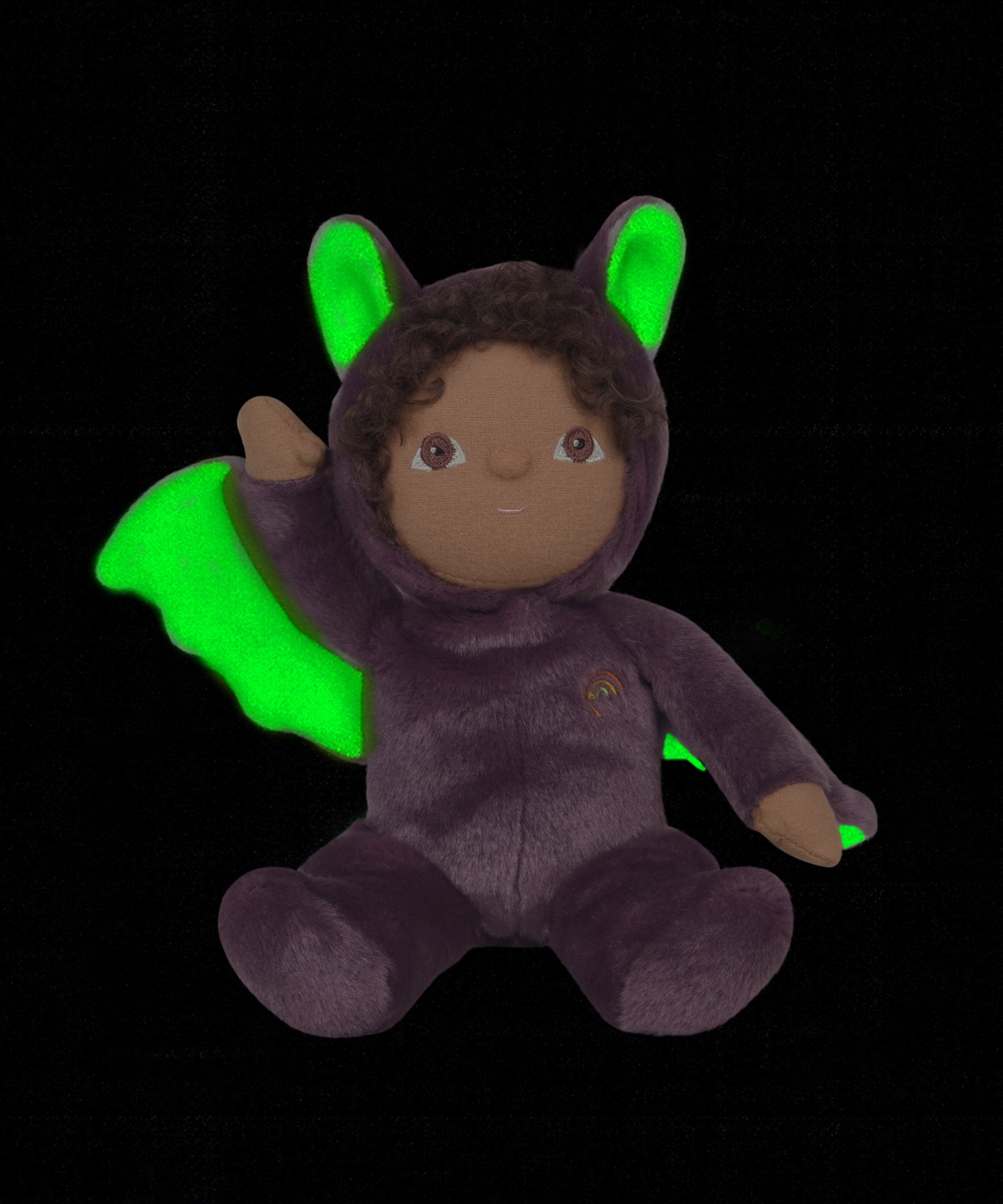 A purple coloured Olli Ella Bowie bat dinky dinkum doll soft toy. The dinky has dark coloured hair and lilac coloured inner wings and ears that glow in the dark. These soft toys are part of Olli Ella's Halloween collection available here at Babipur.