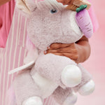 A child pretends to feed the unicorn toy with the carrot