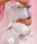 A child pretends to feed the unicorn toy with the carrot