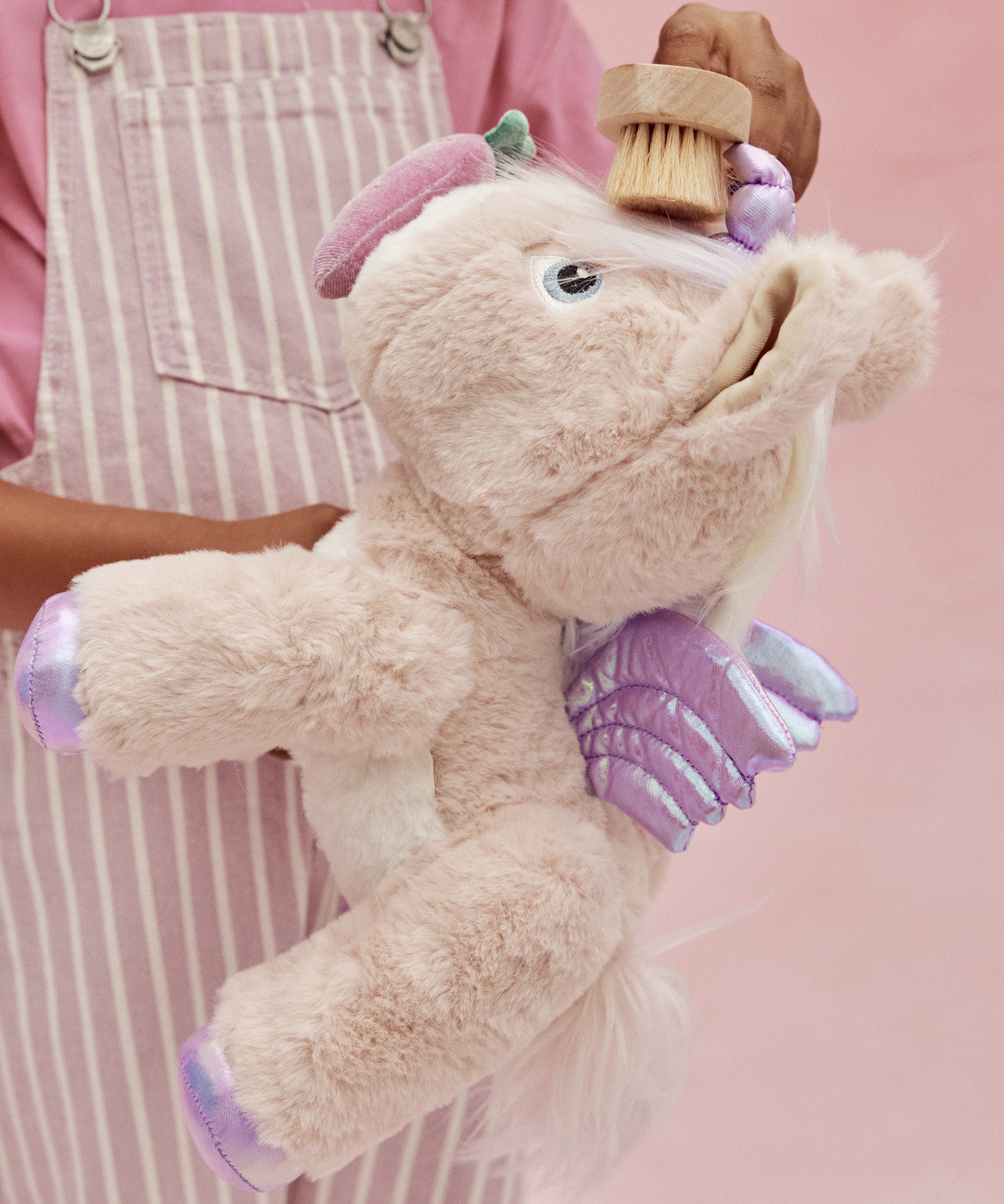 A child brushes the toy unicorn