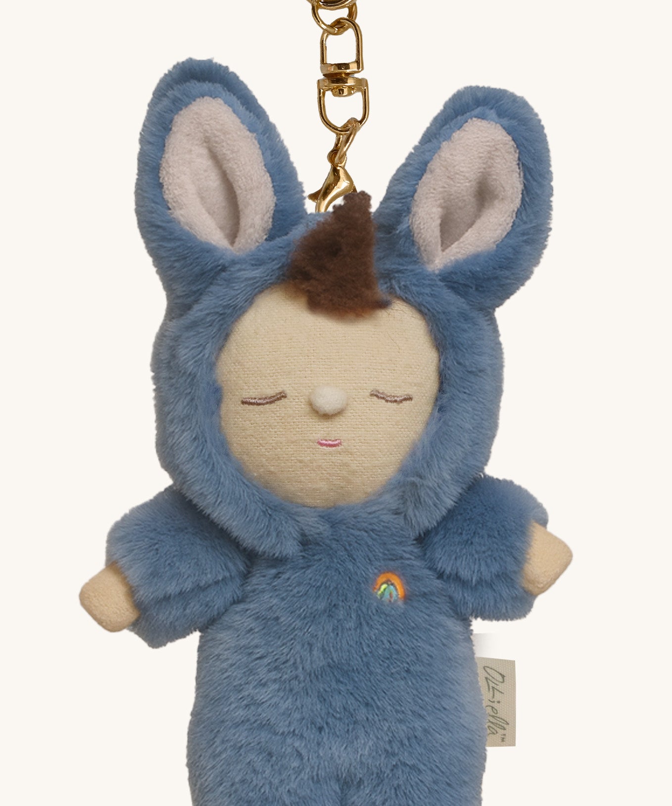 A close up of the Olli Ella bunny twiggy cozy bag charm available at Babipur showing the charm's cute facial features and clip attached to the charm to clip on a backpack