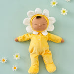 Olli Ella Buttercup Pip Dozy Dinkum Doll laying on a light green surface surrounded by white flower heads.