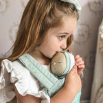 Young girl holding an Olli Ella dozy dinkum moppet ocean dozy dinkum in the ocean print carrier