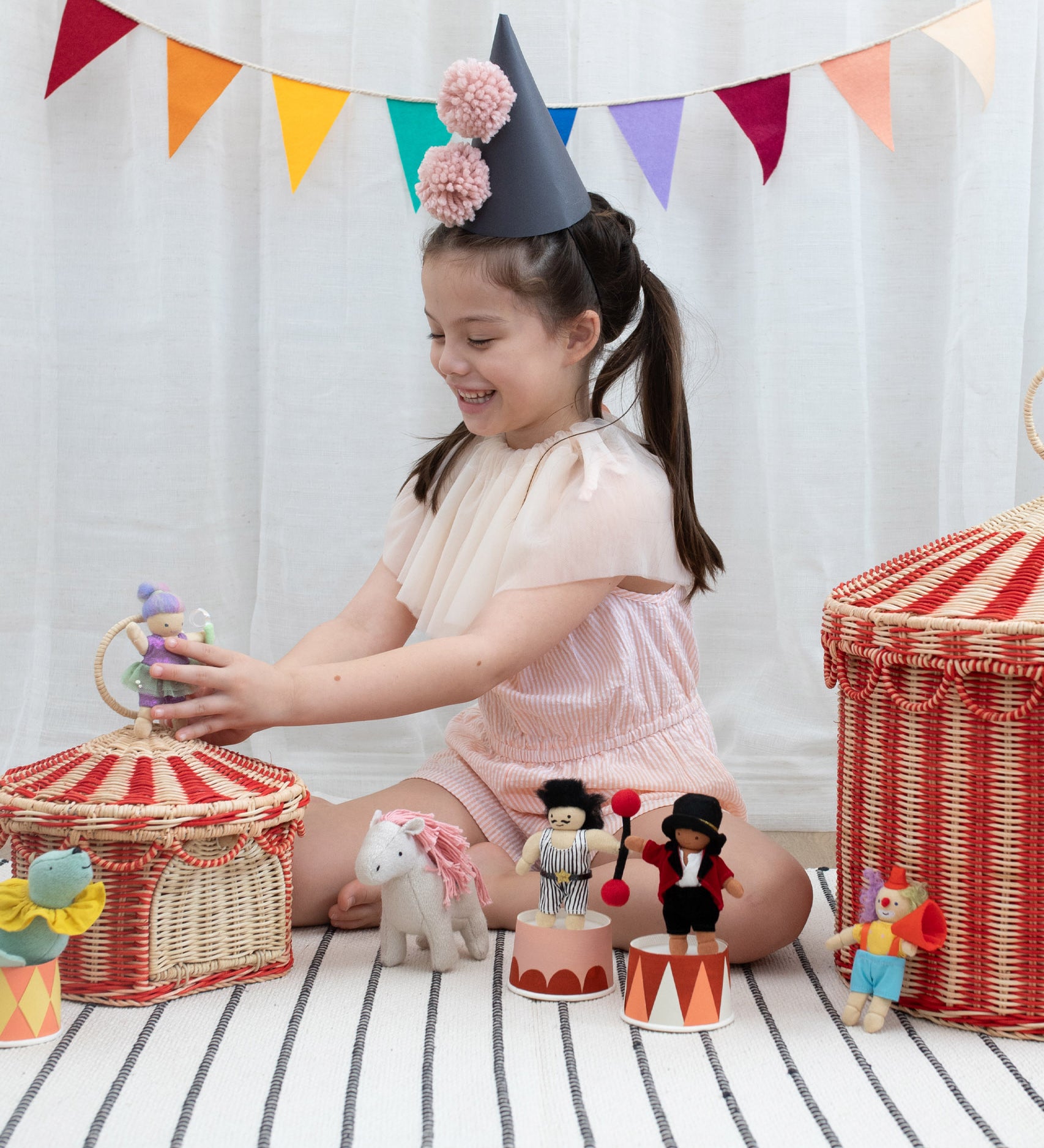 A child playing with the Olli Ella circus holdie folk dolls and the circus basket available at Babipur 