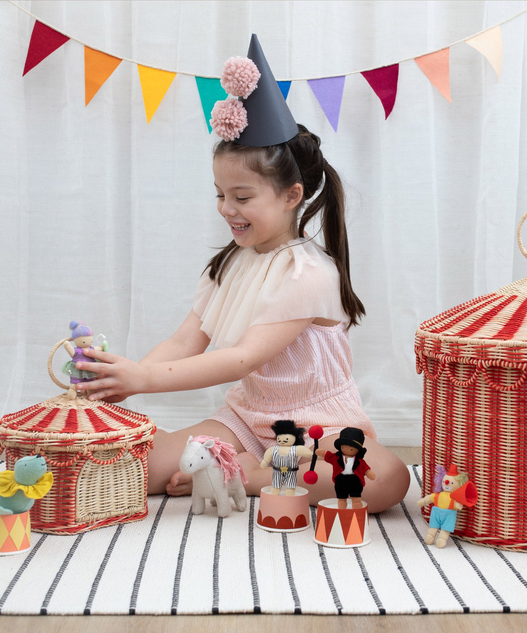A child playing with the Olli Ella circus holdie folk dolls and the circus basket available at Babipur 