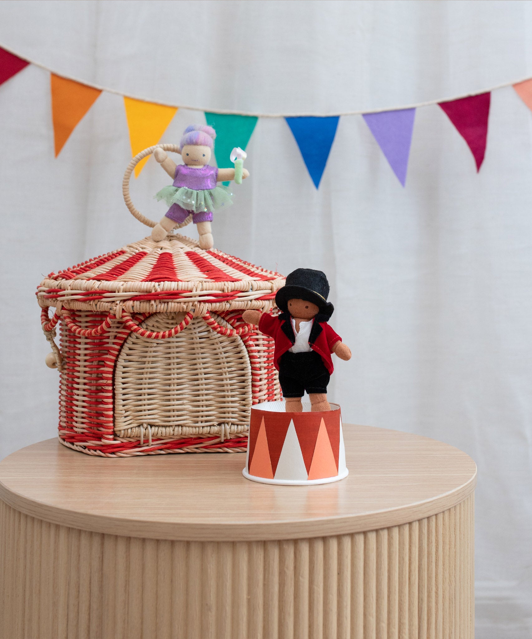 Olli Ella red and white rattan circus basket tent on a wooden surface with 2 circus inspired holdie folk dolls available at Babipur. 