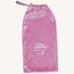 A pink velvet bag for the Olli Ella unicorn doll on a cream background