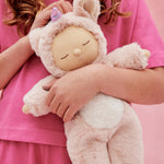 A child holding the pink fluffy Olli Ella dinkum doll 