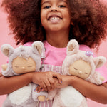 A child holding the lilac and pink fluffy Olli Ella dinkum dolls 