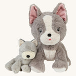 A soft grey and white Olli Ella banjo dinkum puppy sitting next to the soft white and grey Olli Ella dinkum gizmo dog 