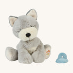 A soft grey and white Olli Ella Dinkum puppy sitting next to a soft magnetic soft toy