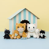 A group image of the Olli Ella binky kitten dolls alongside the cat dinkum dolls with a striped cardboard shelter in the background. These soft toys are available at Babipur.