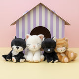 All Olli Ella binky kitten dolls standing in front of a cardboard shelter. These soft toy dolls are available at Babipur.