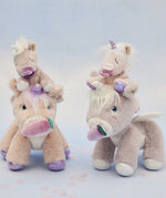 A picture of the dinkum unicorns, with the baby unicorns sat on their heads, with a blue background