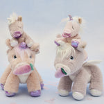 A picture of the dinkum unicorns, with the baby unicorns sat on their heads, with a blue background
