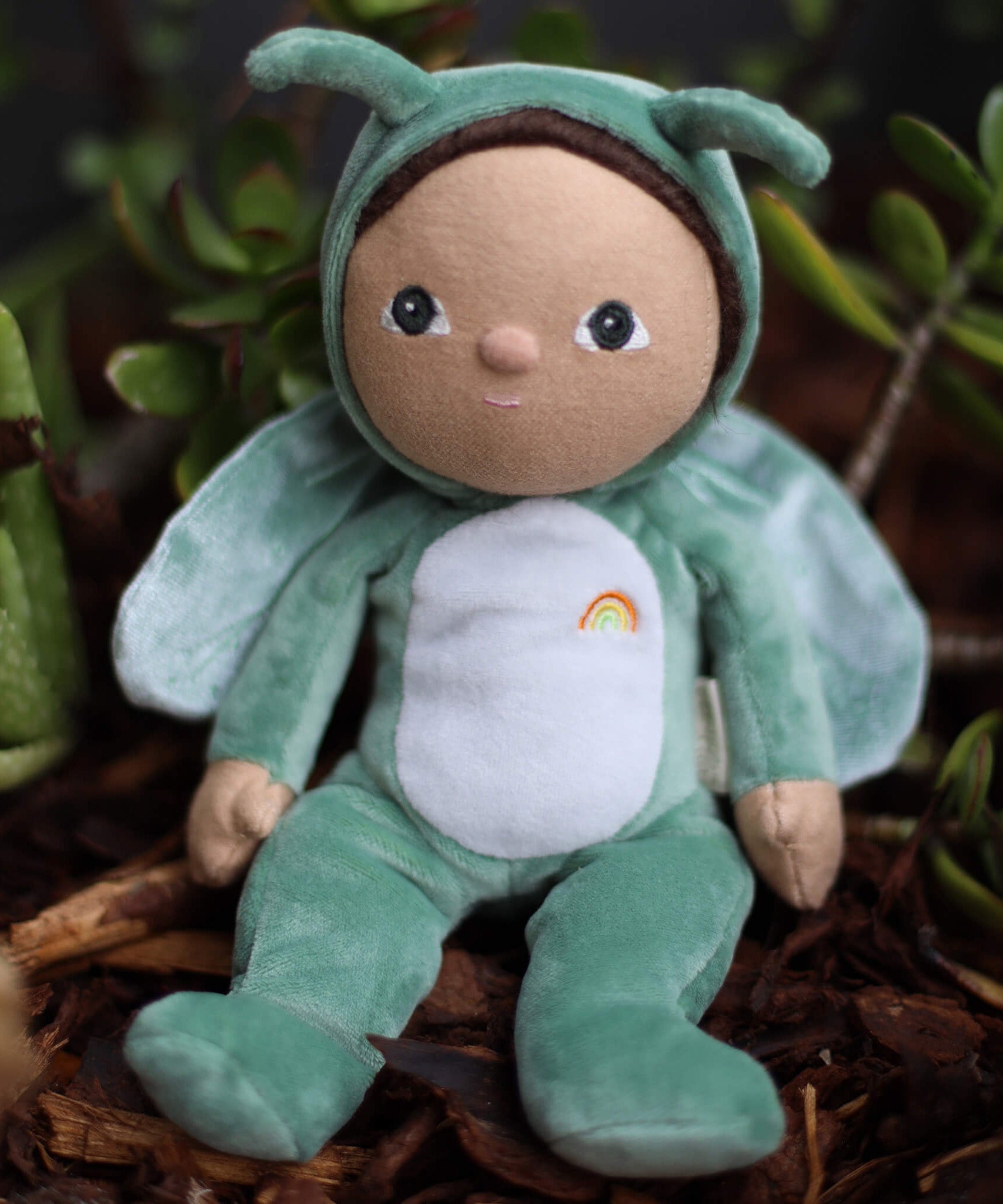 The Olli Ella Dinky Dinkum Doll - Gideon Grasshopper - in a green onesie, with dark brown hair, dark green eyes, grasshopper wings, and antennae.