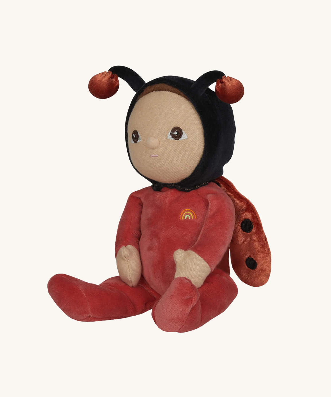 The Olli Ella Dinky Dinkum Doll - Lola Ladybug - in a red onesie with a black hood, brown hair and eyes, spotty ladybird wings, and antennae.