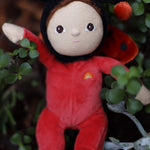 The Olli Ella Dinky Dinkum Doll - Lola Ladybug - in a red onesie with a black hood, brown hair and eyes, spotty ladybird wings, and antennae.
