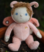 The Olli Ella Dinky Dinkum Doll - Millie Moth - with a peach coloured onesie, moth wings, curly ginger hair, and antennae.