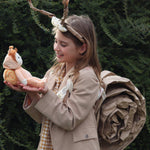 A girl dressed up in a homemade snail costume, holding Scottie Snail, the Dinky Dinkum Doll from Olli Ella.