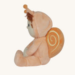 A side profile view of the Olli Ella Dinky Dinkum Doll - Scottie Snail - in a soft light orange onesie with curly red hair, a snail shell on his back, and antennae.