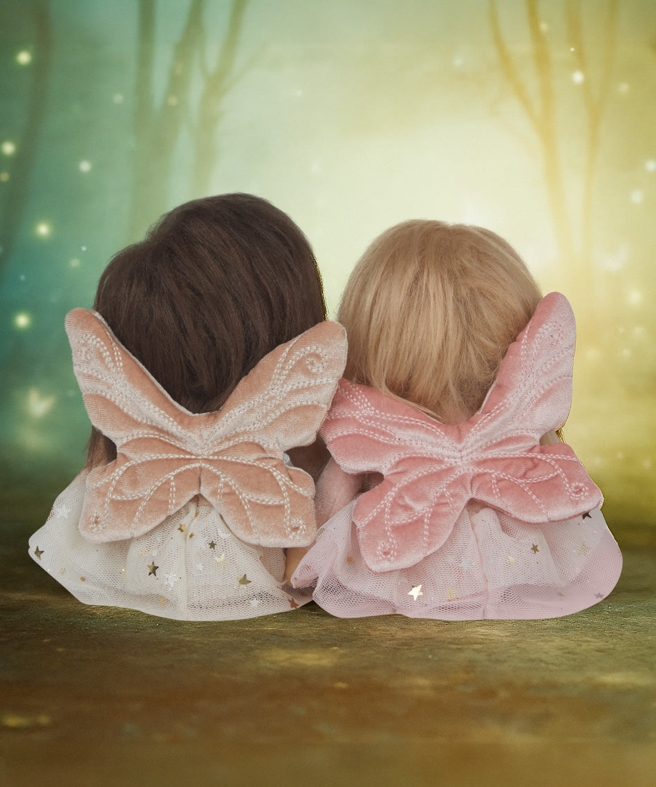 Olli Ella Fiona and Faye fairy dinky dinkum dolls sitting next to eachother and facing a fantasy background and showing the wing detail