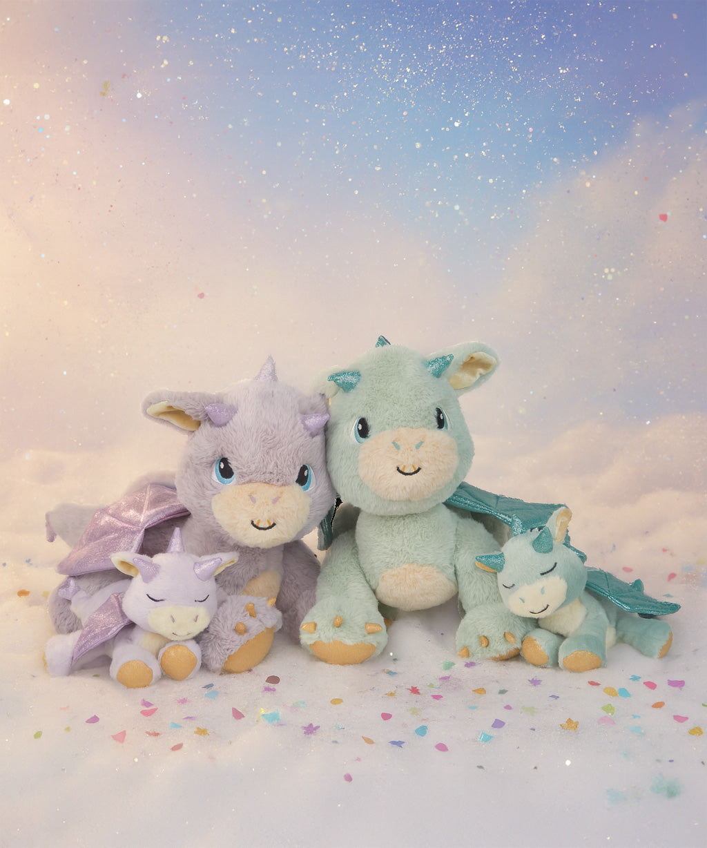 All Olli Ella dragon dolls in a group with a dreamy background and falling confetti. These two dragons are available at Babipur.