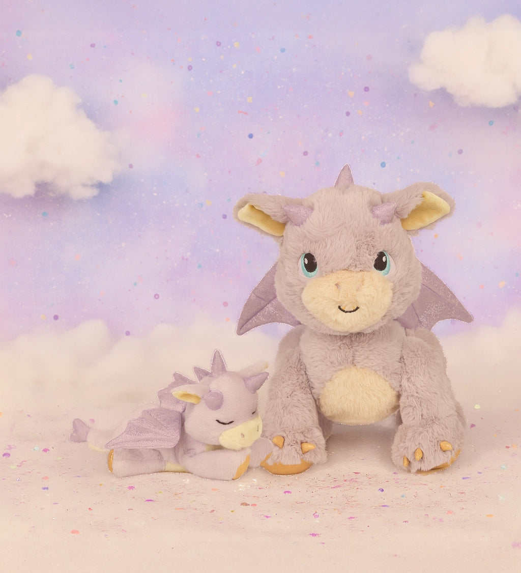 A Olli Ella flare dinkum dragon doll standing next to misty the binky dragon with a dreamy background. These two dragons are available at Babipur.