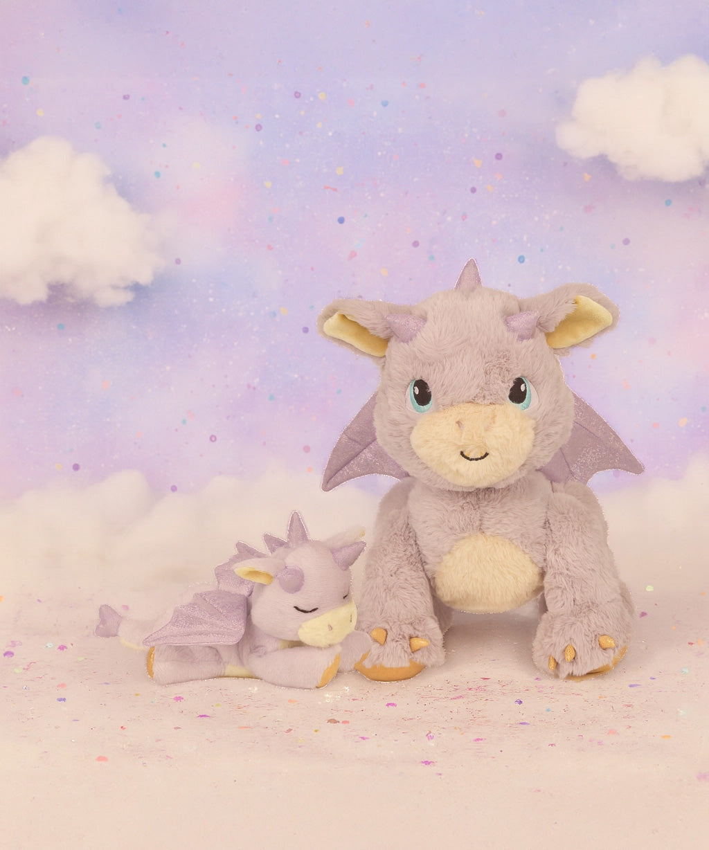 A Olli Ella flare dinkum dragon doll standing next to misty the binky dragon with a dreamy background. These two dragons are available at Babipur.