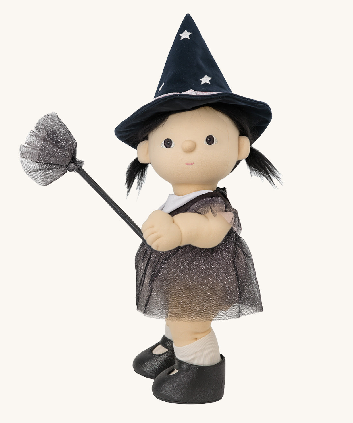 A side on view of the Olli Ella Wendy Witch dream Dinkum doll. A dinkum doll with a black dress, witches hat, black shoes and a magnetic broom accessory. This doll is part of Olli Ella's Halloween collection available here at Babipur.