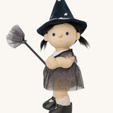 A side on view of the Olli Ella Wendy Witch dream Dinkum doll. A dinkum doll with a black dress, witches hat, black shoes and a magnetic broom accessory. This doll is part of Olli Ella's Halloween collection available here at Babipur.