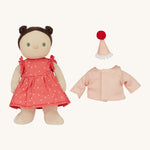 Olli Ella Dress Me Dinky - Sophie Sundae, a doll with brown hair and green eyes wearing a pink polka dot dress, her light pink cardigan and a pink party hat is next to her. Cream background.