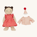 Olli Ella Dress Me Dinky - Sophie Sundae, a doll with brown hair and green eyes wearing a pink polka dot dress, her light pink cardigan and a pink party hat is next to her. Cream background.