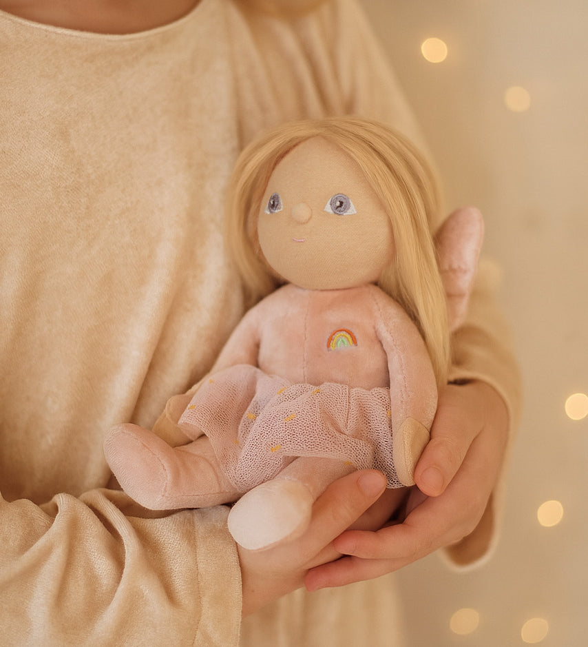 A child clutching the Olli Ella Fiona fairy dinky dinkum doll available at Babipur. 