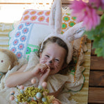 A child wearing the pink Olli Ella Fluffle Bunny Ear Headband in Pink.