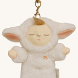 A close up of the Olli Ella lamby pookie cozy bag charm available at Babipur showing its cute ears and clip attached to the charm to clip on a backpack