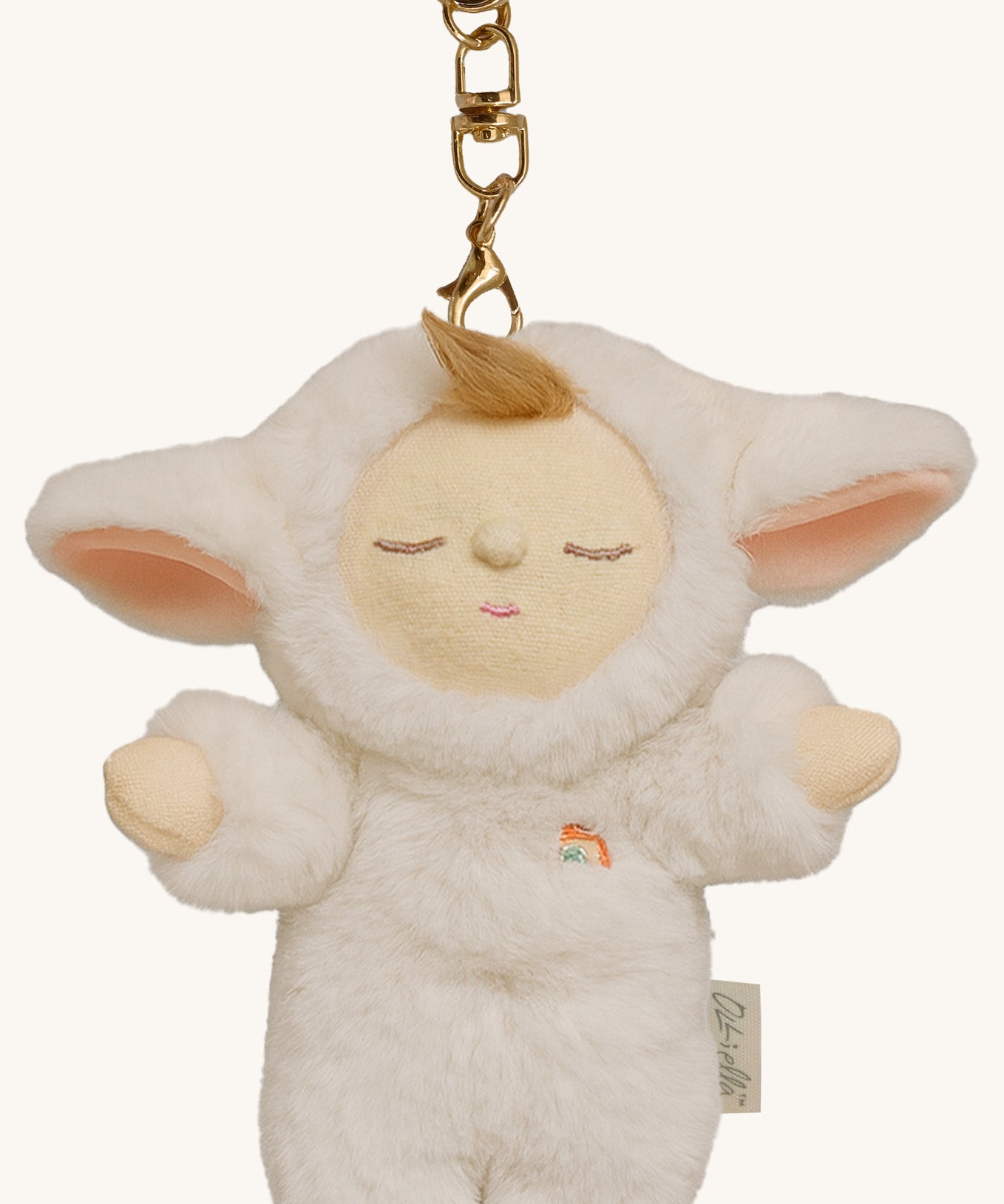 A close up of the Olli Ella lamby pookie cozy bag charm available at Babipur showing its cute ears and clip attached to the charm to clip on a backpack