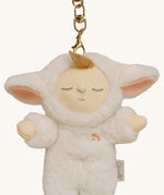 A close up of the Olli Ella lamby pookie cozy bag charm available at Babipur showing its cute ears and clip attached to the charm to clip on a backpack