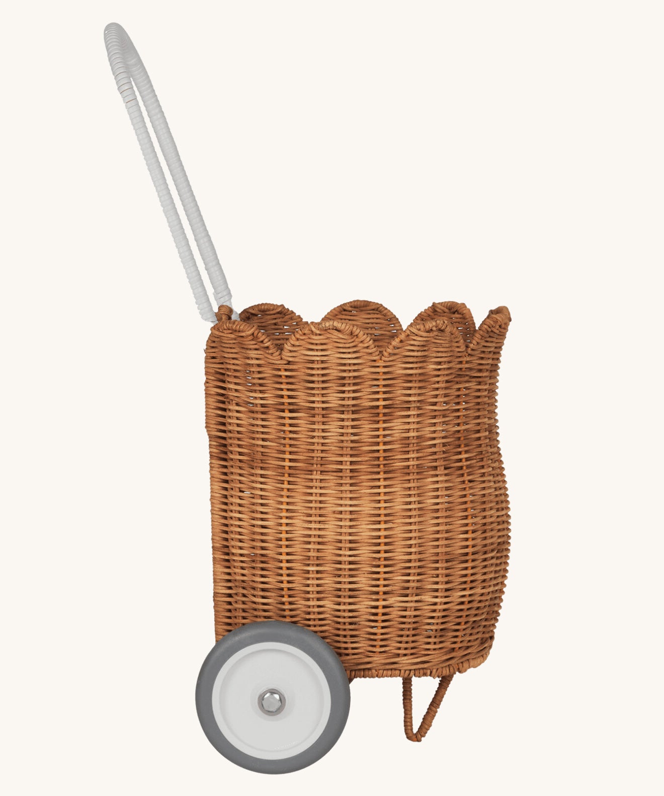 A side view of the Olli Ella Natural Rattan Petal Luggy.