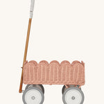 A side profile of the Olli Ella Seashell Pink Rattan Petal Wonder Wagon.