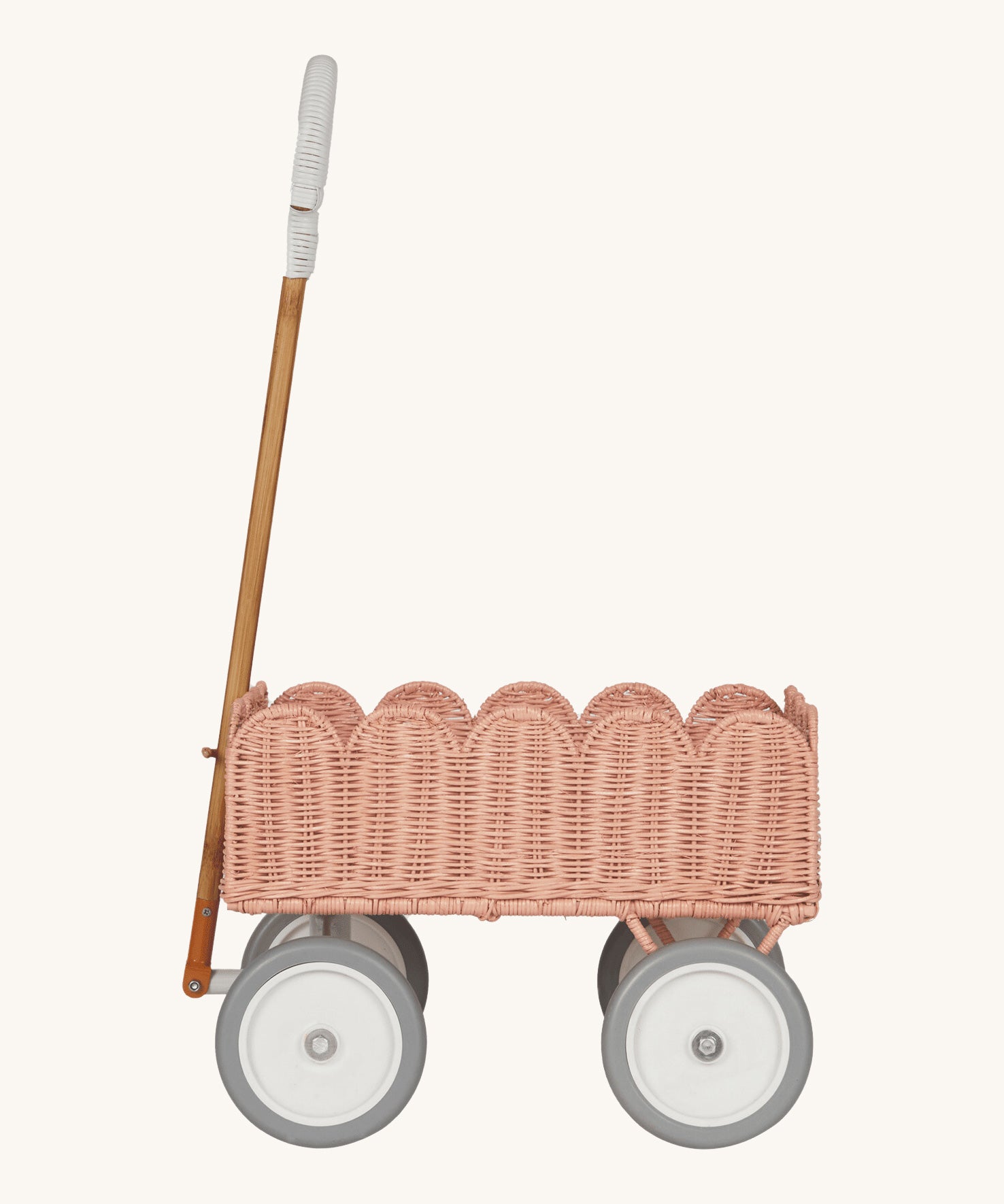 A side profile of the Olli Ella Seashell Pink Rattan Petal Wonder Wagon.