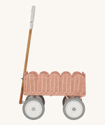 A side profile of the Olli Ella Seashell Pink Rattan Petal Wonder Wagon.