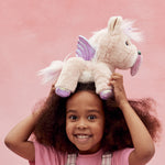 A child holding the toy unicorn above her head