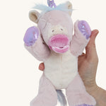 A hand holding the baby unicorn for size reference