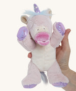 A hand holding the baby unicorn for size reference