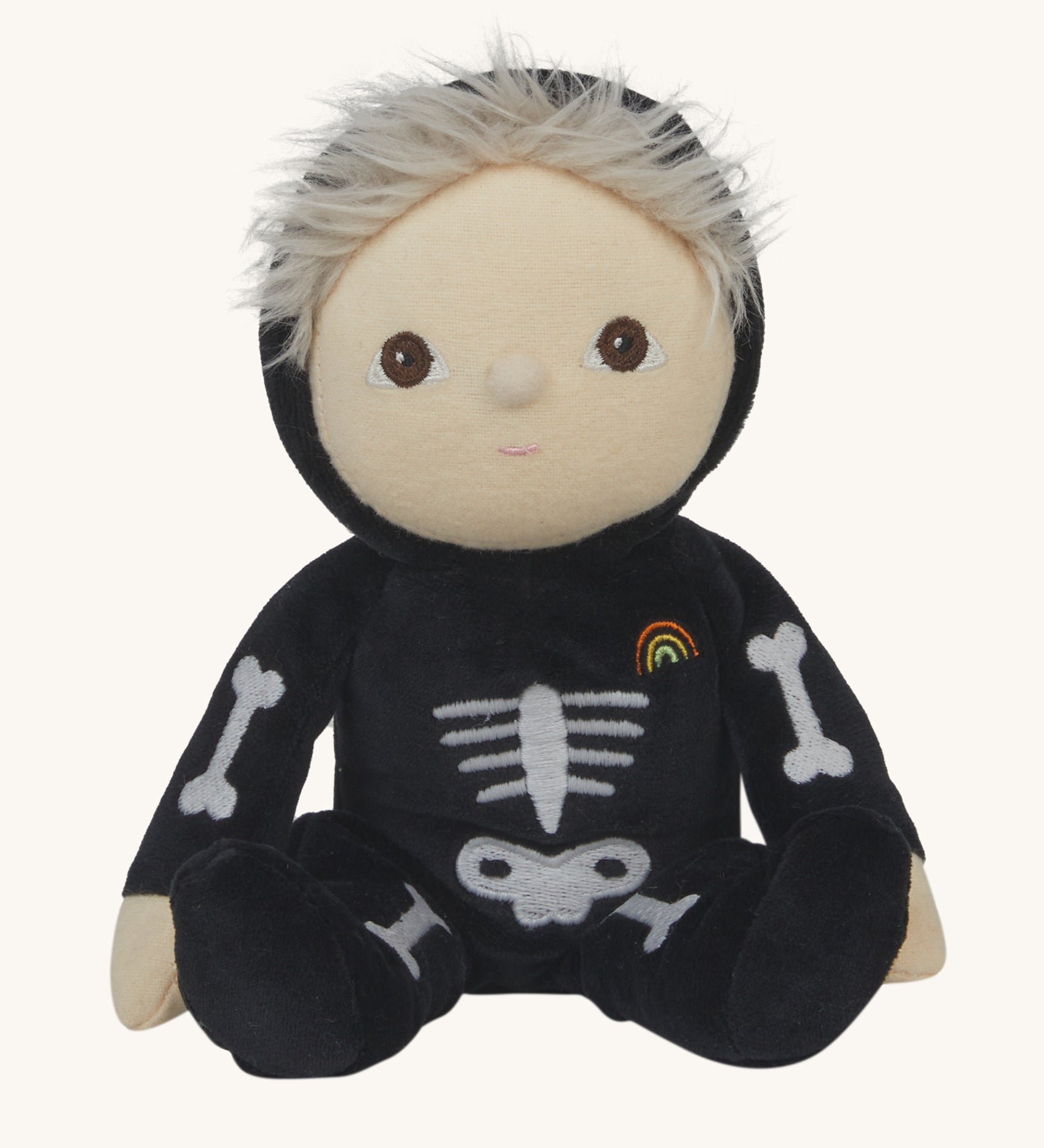 Olli Ella Scully Skeleton Dinky Dinkum Doll soft toy. The doll features glow in the dark bone details on the front along with a small embroidered rainbow on the chest. These soft toys are part of Olli Ella's Halloween collection available here at Babipur.