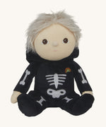 Olli Ella Scully Skeleton Dinky Dinkum Doll soft toy shown with it's hood down, the doll has light blonde hair. The doll features glow in the dark bone details on the front along with a small embroidered rainbow on the chest. These soft toys are part of Olli Ella's Halloween collection available here at Babipur.