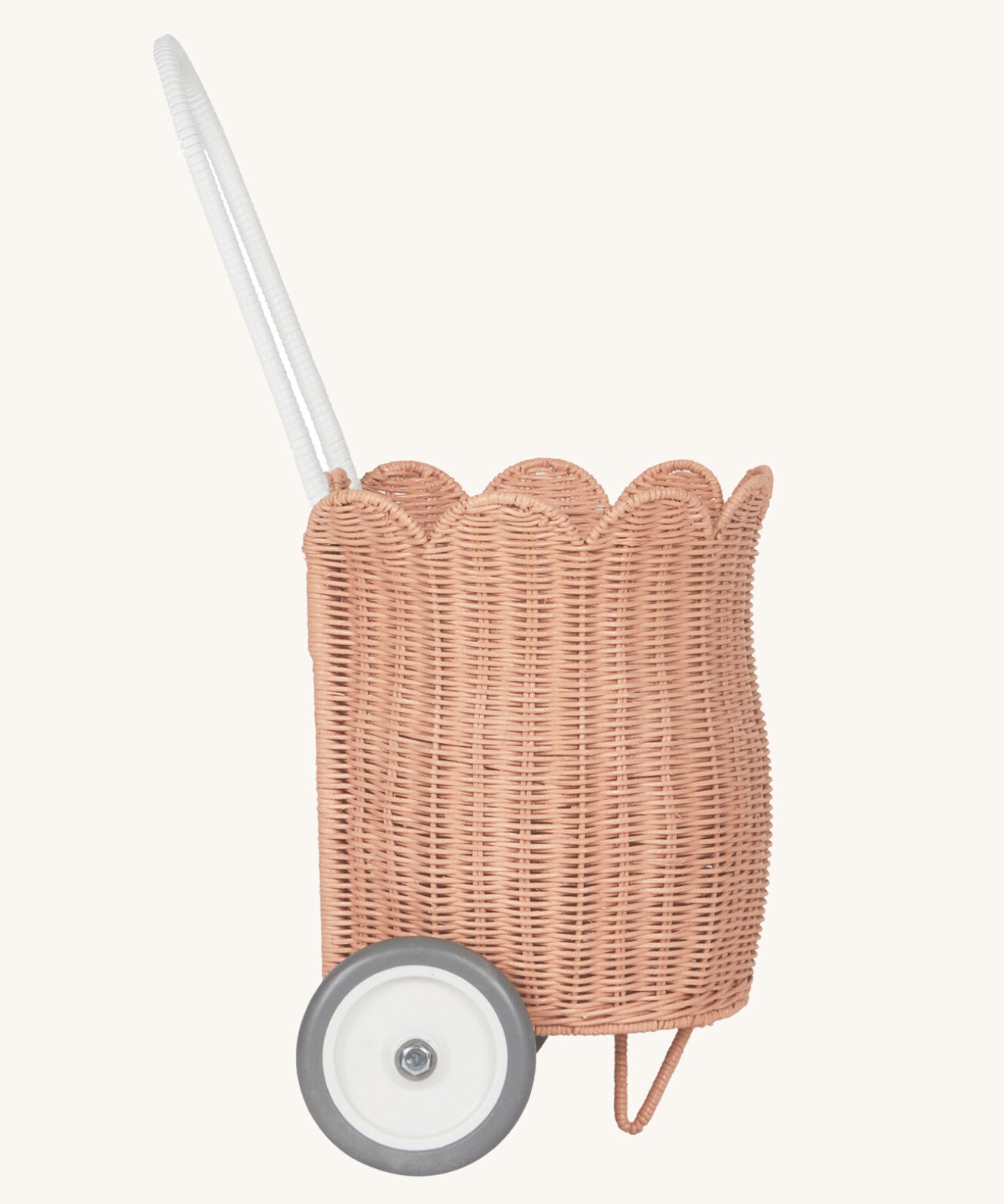 A side view of the Olli Ella Seashell Pink Rattan Petal Luggy.