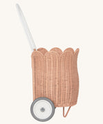 A side view of the Olli Ella Seashell Pink Rattan Petal Luggy.